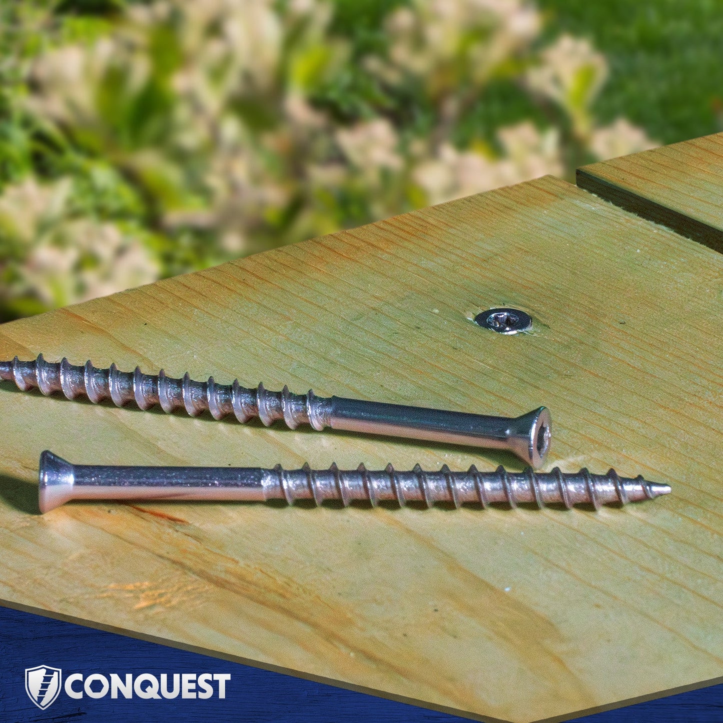 Two screws on a wooden surface with 'Conquest' branding.