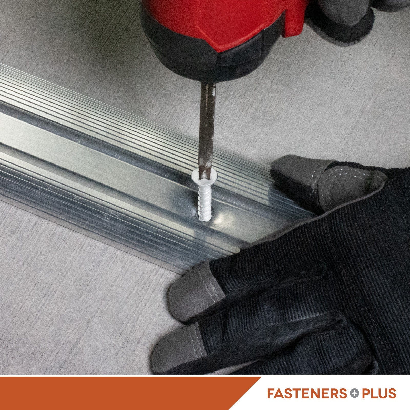 White concrete screw drilled into metal framing on concrete