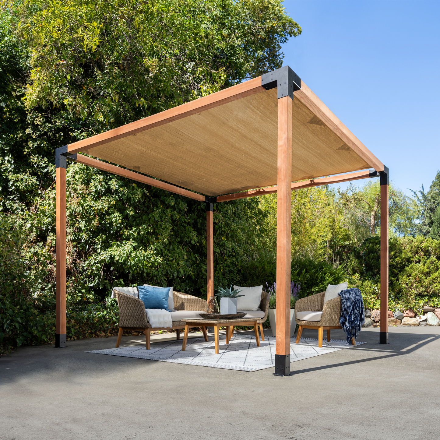 Wooden pergola with outdoor furniture under a clear blue sky