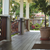 Porch with wooden floor, white columns, and potted plant