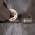 a gloved hand putting a squirter washer on a threaded bolts