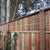 Wooden fence with lattice design and trees in the background