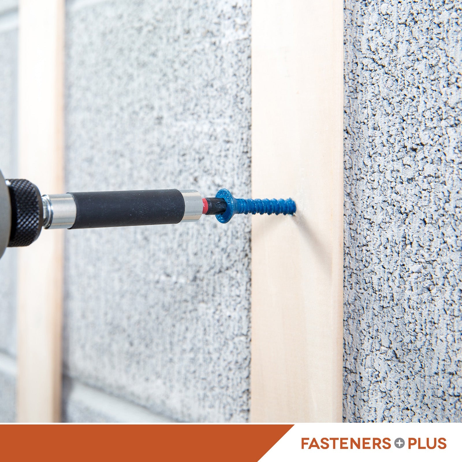 Drill bit being used on a concrete surface with 'Fasteners Plus' branding.