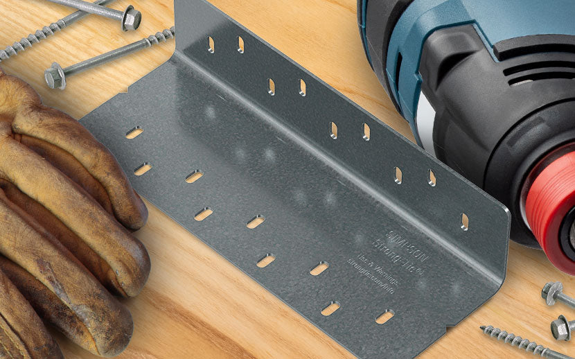 Metal angle bracket with power drill, gloves, and screws on a wooden surface