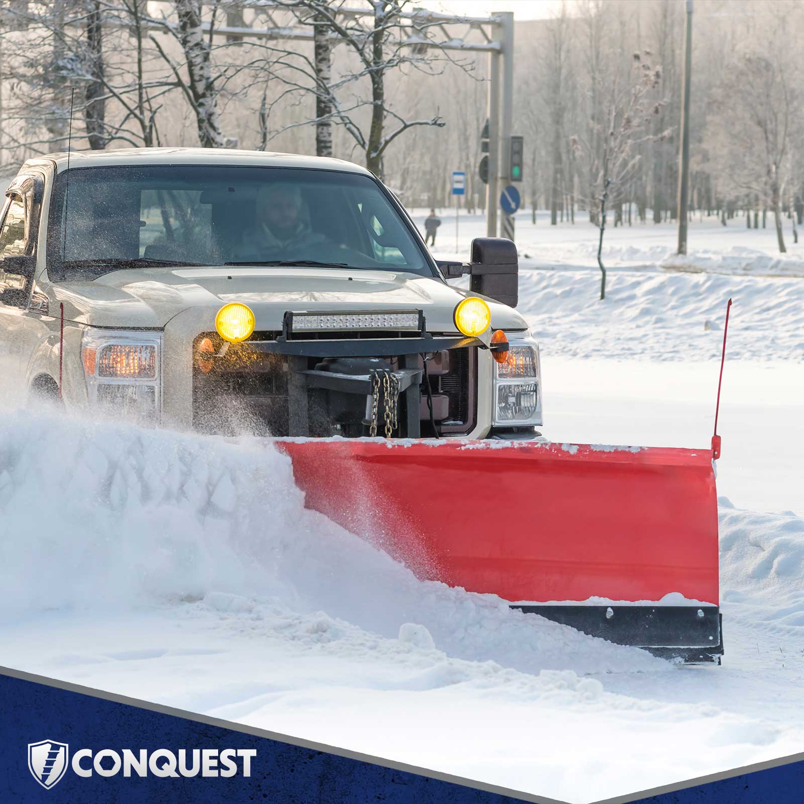 White truck with a red snow plow clearing snow in a winter landscape