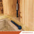 Close-up of a blue concrete screw anchor installed in a wooden frame and concrete base