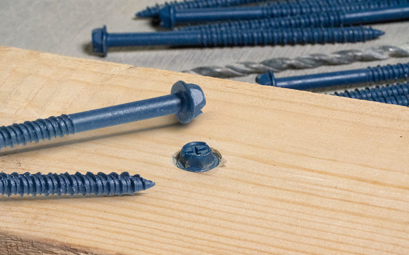Blue concrete screws on a wooden surface