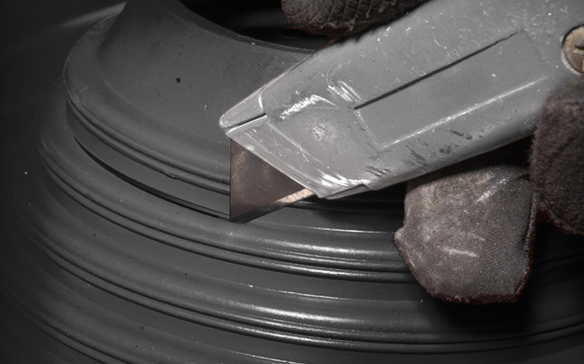 Using a utility knife to cut a rubber roof boot to size