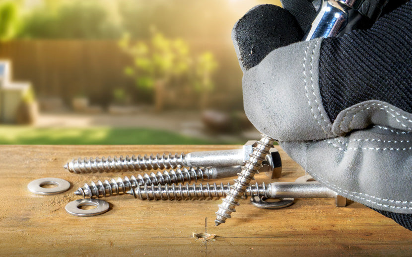 A contractor using a lag bolt for an outdoor build