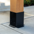 Black Decorative Post Base installed on Wooden Post on concrete floor