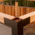 Wooden beam with metal bracket against a wooden fence background