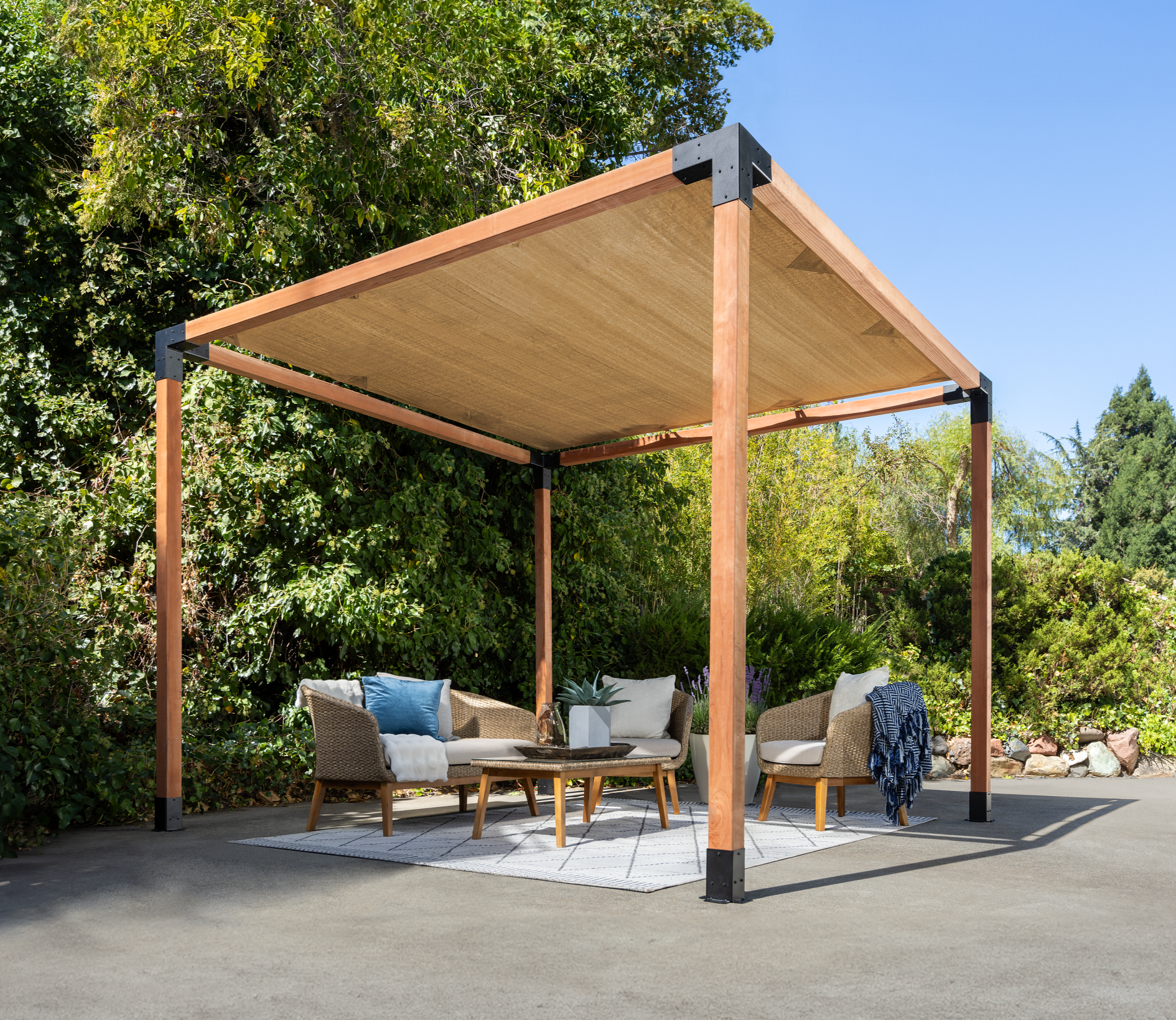 Wooden pergola with outdoor furniture under a clear blue sky