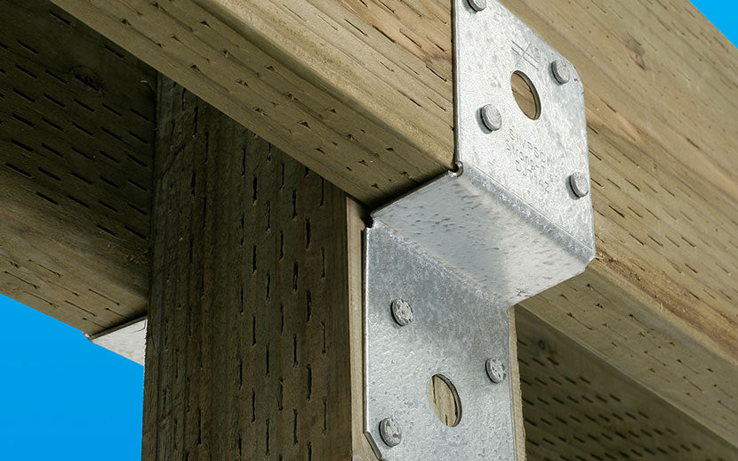 Metal deck tie attached to wooden beams against a blue sky.