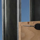Wooden board with a screw and drill bit against a metal frame and blue sky background