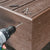 Drilling into a composite deck with a drill and drill bit.