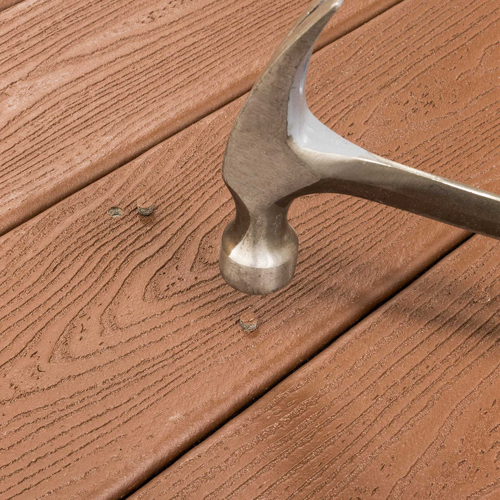 hammering a deck screw plug on composite decking