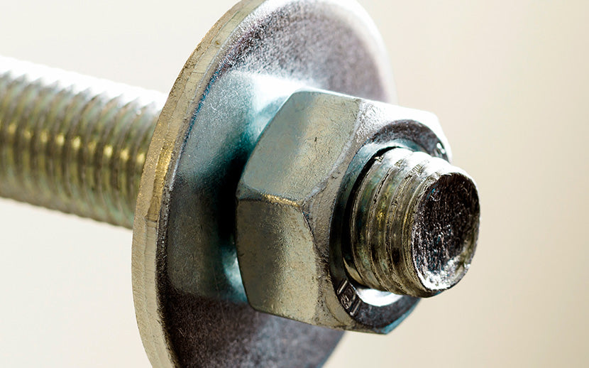 Close-up of a metal bolt, hex nut, and fender washer