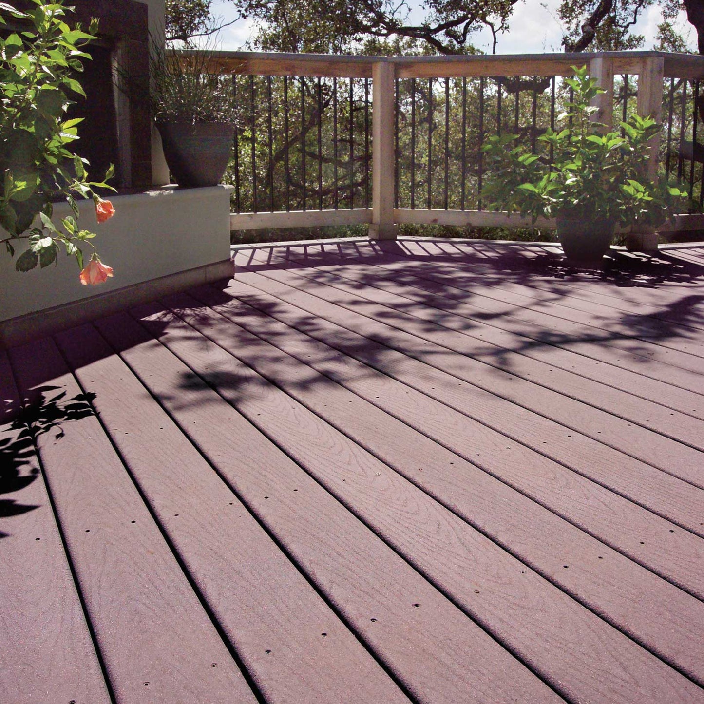 Composite deck with potted plants and a railing in the background