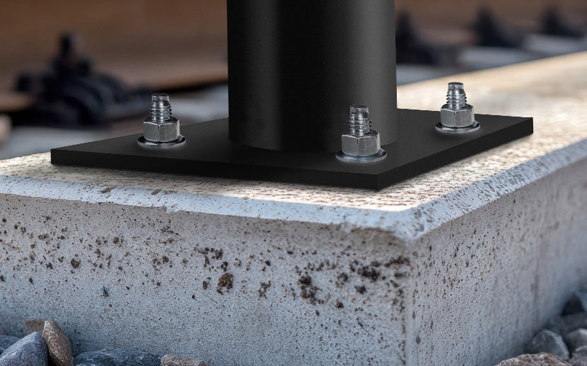 Metal base plate with wedge anchors on a concrete surface